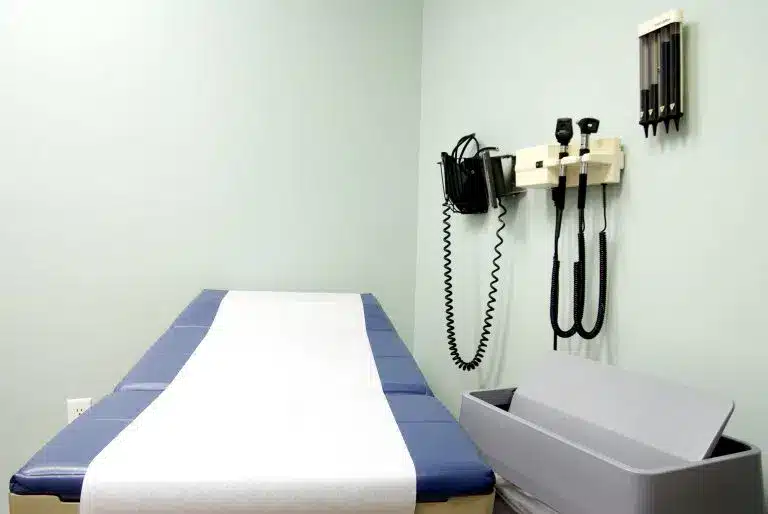 Clean medical exam room with sanitized equipment and a treatment table, showcasing the importance of reliable commercial pest control in healthcare facilities.