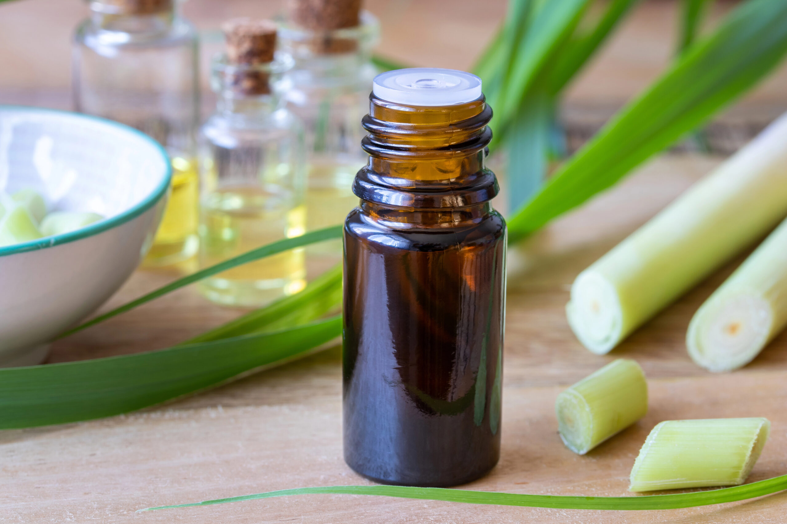A bottle of essential oil with fresh lemon grass